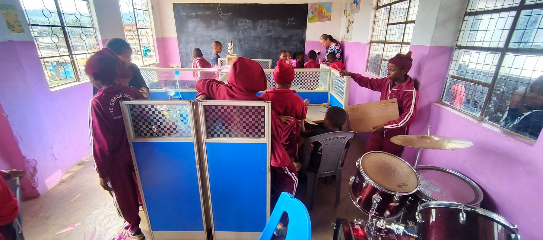 Learners at work in the school recording studio, with a drum kit beside them